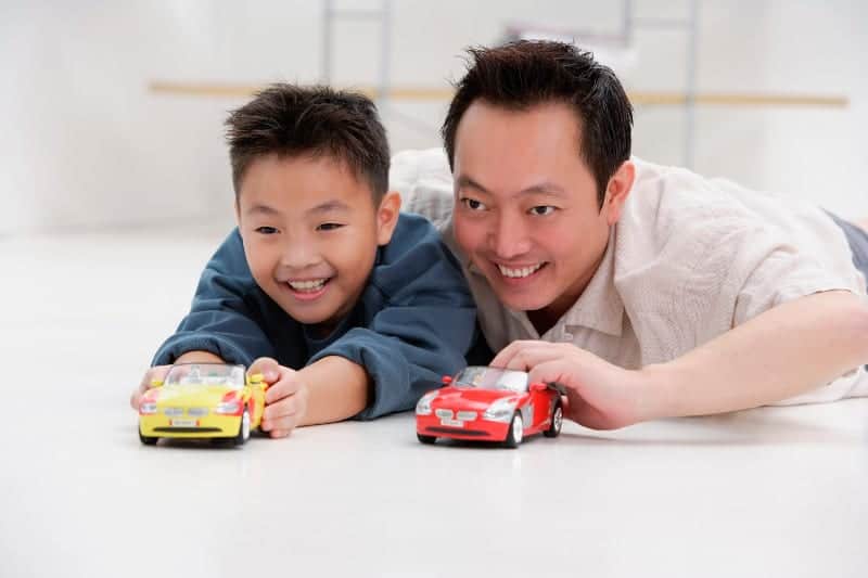 father and son playing with cars