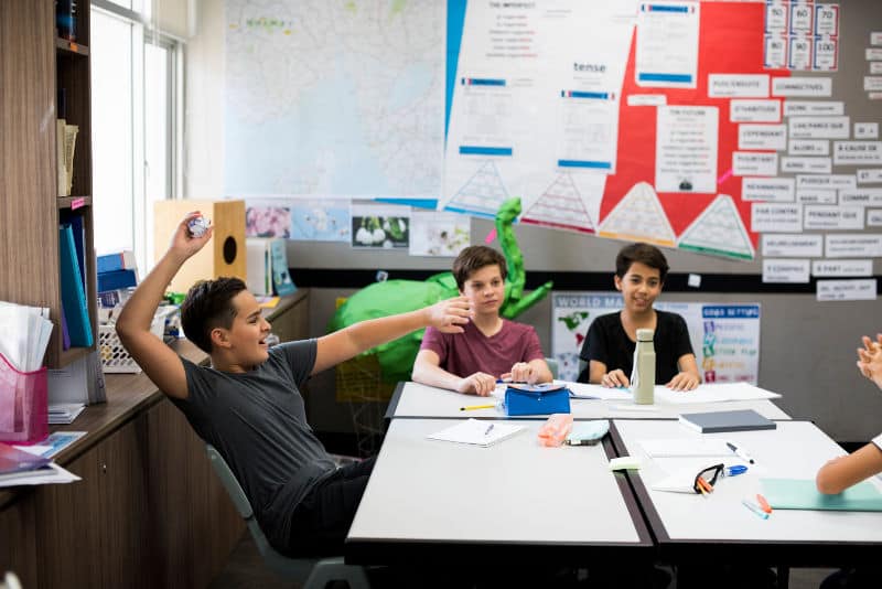 Disruptive boy throwing paper in the classroom