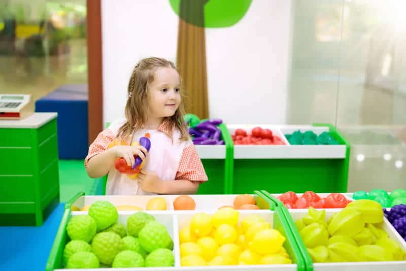 ELL learner in preschool counting toy fruit
