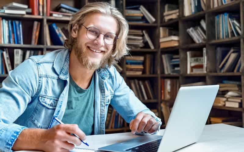 smiling male student studying online