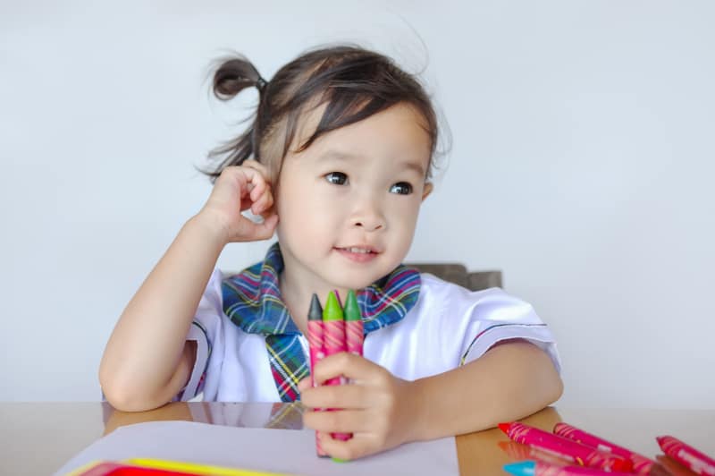 pretty asian preschool girl with crayons
